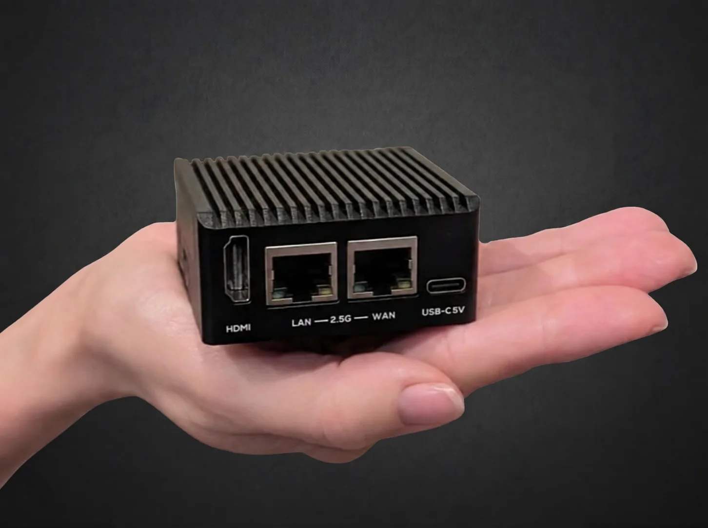 NetCollab Xpresso in einer Hand, mit kompaktem Gehäuse und zwei sichtbaren Ethernet-Anschlüssen